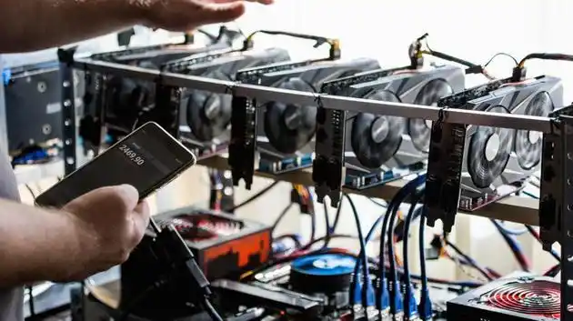 A miner inspecting rows of mining rigs in a large warehouse, highlighting the scale and complexity of a mining operation.